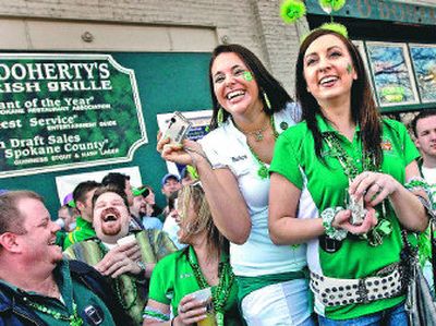 
Kadra Dueber, left, and Tonya Absalonson cheer during the St. Patrick's Day Parade in front of  O'Doherty's Irish Grille on Saturday. 
 (Photos by Brian Plonka / The Spokesman-Review)