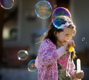 ORG XMIT: WAWEN101 Deanna Sherrill, 8, Wenatchee, Wash., grimaces as the spray from a bursting bubble hits her head while she and her sister, Ashlee, (not seen), try out their new bubble makers they bought on their first day of spring break Monday, March 30, 2009.  (AP Photo/The Wenatchee World, Don Seabrook) (Don Seabrook / The Spokesman-Review)