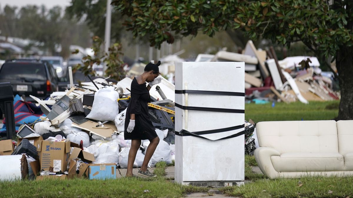 Lori Butler wipes her brow Tuesday as she moves debris from her home, which was gutted by the flooding, in the aftermath of Hurricane Ida in LaPlace, La.  (Gerald Herbert)
