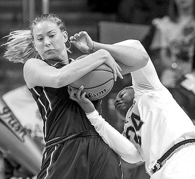 Washington’s Katie Collier, left, battles for the ball with Notre Dame’s Arike Ogunbowale. (Robert Franklin / Associated Press)