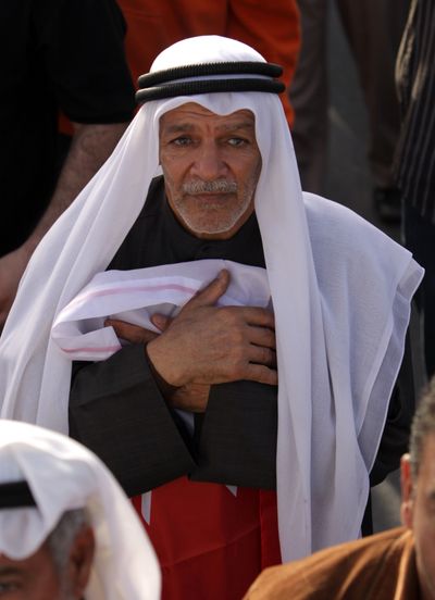 An anti-government protester clutches the Bahraini flag during a march Tuesday in Manama. (Associated Press)