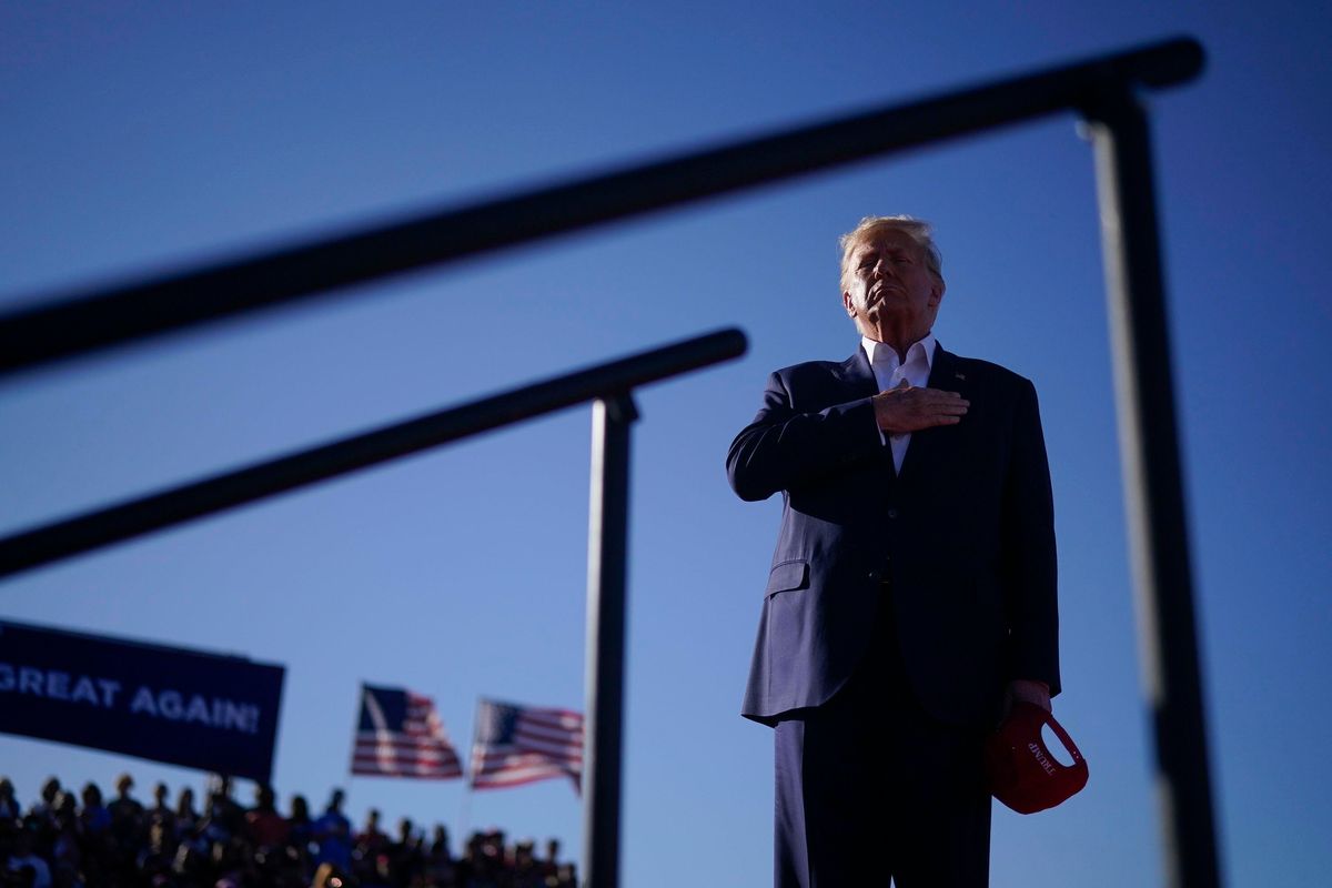 Former president Donald Trump stands for the Pledge of Allegiance at a campaign rally on March 25 at Waco Regional Airport in Waco, Texas.  (Jabin Botsford/The Washington Post)