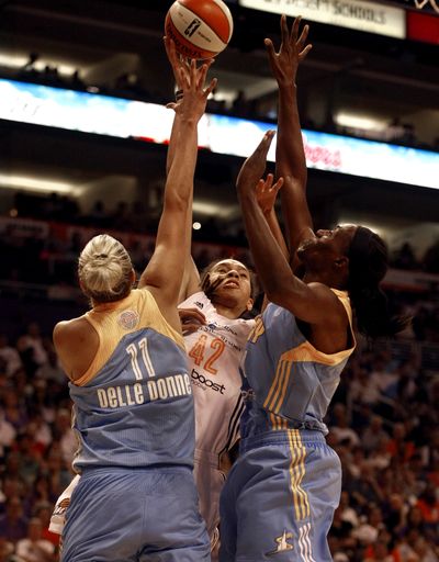 Phoenix’s Brittney Griner shoots over Chicago’s Elena Delle Donne and Sylvia Fowles. (Associated Press)