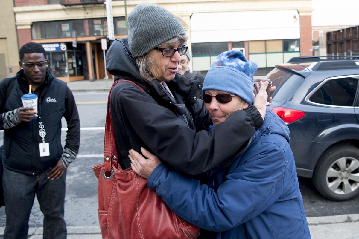 Ilze Zarins-Ilgen, left, a homeless outreach coordinator from the Community Health Association of Spokane, embraces Daun Marsh, 70, who is without a home and was recently diagnosed with multiple sclerosis, on Wednesday, March 23, 2016, outside Shalom Ministries in Spokane. (Tyler Tjomsland / The Spokesman-Review)