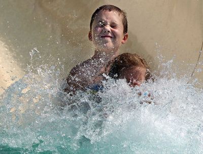 
Shane Lembeck, 10, closes his eyes as the water splashes him and his sister, Nicole, 6, when they reach the end of the Big Dipper slide at SplashDown Family Waterpark.
 (Liz Kishimoto / The Spokesman-Review)