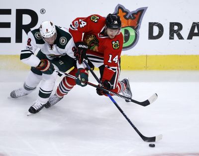 Chicago Blackhawks' Richard Panik (14) and Minnesota Wild's Mikko Koivu battle for the puck during the first period of an NHL hockey game Sunday, March 12, 2017, in Chicago. (AP Photo/Charles Rex Arbogast) ORG XMIT: CXA113 (Charles Rex Arbogast / AP)