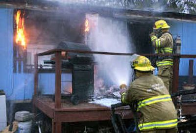 
Spokane firefighters douse the remaining flames of a mobile home fire. 
 (Dan Pelle / The Spokesman-Review)
