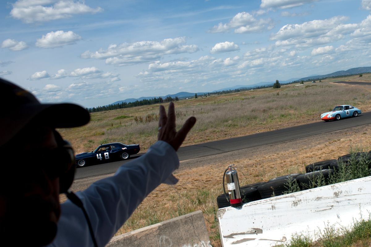 Officials wave in racers in the Historic Large Bore class the during the Spokane Festival of Speed on Sunday at Spokane County Raceway. (Tyler Tjomsland)