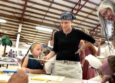 
Jenny Meyer, center, and her daughter, Grace, 5, enter photos in the county fair at the Bonner County Fairgrounds on Monday.  A film about Jenny Meyer's fight with cancer will be shown Thursday as part of the Idaho Panhandle International Film Festival. 
 (Joe Barrentine / The Spokesman-Review)