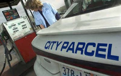 
Karen Campbell gasses her City Parcel vehicle at the end of her shift on Friday and watches the numbers spin on the pump. A gallon of unleaded costs about $2.50 at most pumps in the Spokane area. 
 (Christopher Anderson/ / The Spokesman-Review)