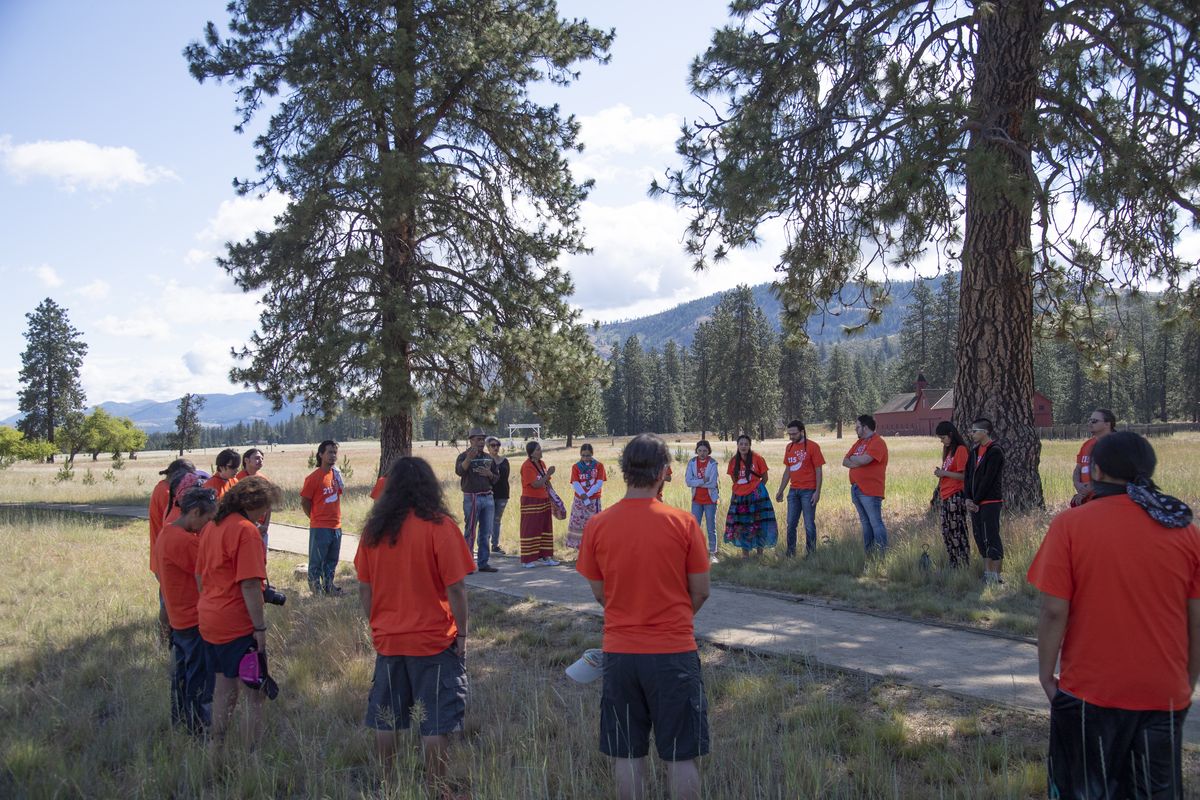A large group of Native youth stand in a circle at Fort Spokane, a historical site near the confluence of the Spokane and Columbia Rivers Tuesday, June 15, 2021 and hear about their tribes’ history in the area before setting out in traditional cedar canoes on a four-hour paddle up the Columbia. Fort Spokane was a military post founded in 1880, but the compound also had a school to educate Native kids, a process which was not always voluntary.  (Jesse Tinsley/The Spokesman-Review)