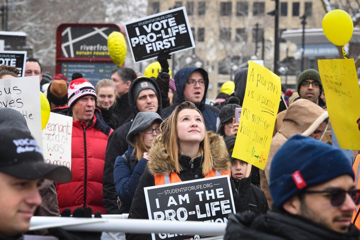 Aunna Isakson, 19, of Spokane, lifts her eyes upward during the beginning moment of the Walk for Life Northwest rally on Saturday in Riverfront Park. (Dan Pelle / The Spokesman-Review)
