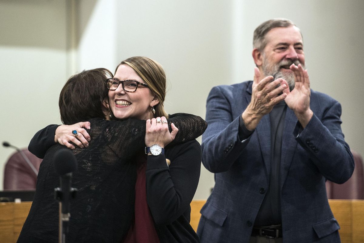 FILE - Kate Burke, center, beams with delight as she is hugged by her mother, Marggy Burke, and applauded by her father, Jim Burke, after she she was sworn in to replace Amber Waldref on the Spokane City Council, Thursday, Dec. 21, 2017 in the council chambers. (Dan Pelle / The Spokesman-Review)