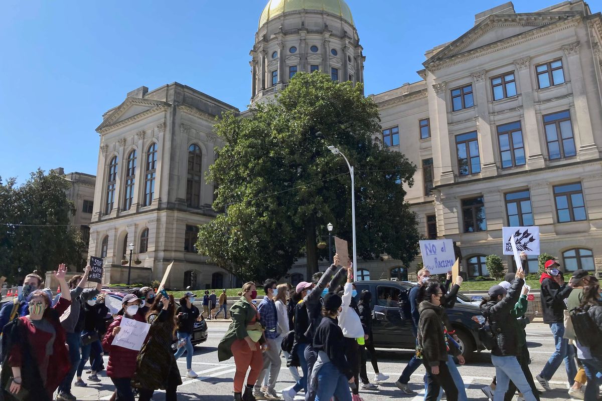 Hundreds of people gather in a park across from the Georgia state Capitol in Atlanta to demand justice for the victims of shootings at massage businesses days earlier, Saturday, March 20, 2021 in Atlanta.  (Candice Choi)