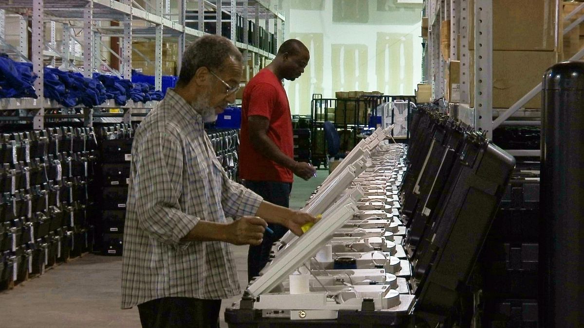 This Sept. 22, 2016, file photo shows employees of the Fulton County Election Preparation Center in Atlanta test electronic voting machines. (Alex Sanz / Associated Press)
