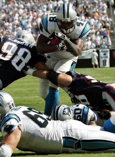 
Carolina's Stephen Davis runs through New England's Chad Brown (98) and Matt Chatham for his third touchdown of the game Sunday.
 (Associated Press / The Spokesman-Review)
