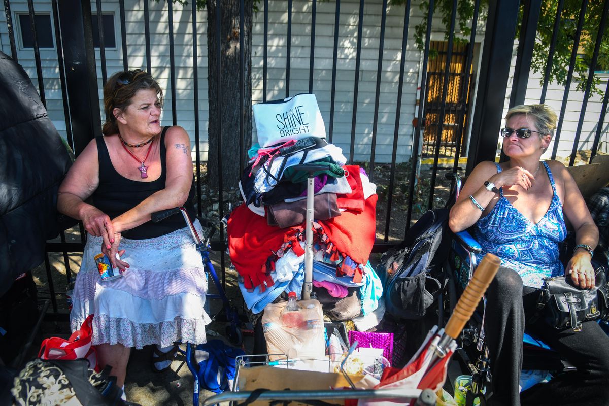 Sharon Richard, 54, and Amy Hopwood, 47, find a shady spot to sit and pass the time away, Tuesday, July 24, 2018 outside the House of Charity. HOC is ending it’s 24/7 shelter policy on Sept. 1. (Dan Pelle / The Spokesman-Review)