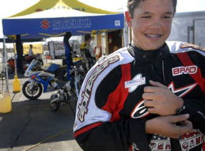 
Brad Baker, 14, prepares to remove his leathers after doing a few laps on his 125cc street bike Thursday.
 (The Spokesman-Review)