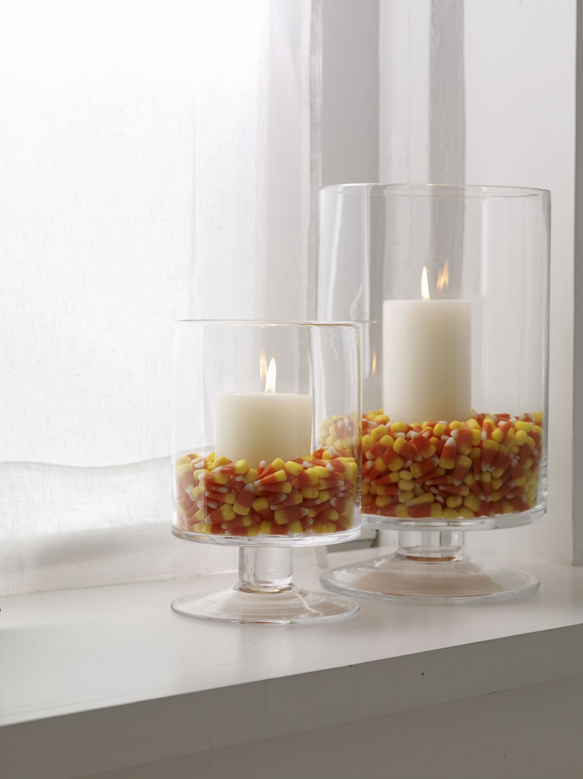 Left: Glass hurricanes filled with colorful candy corn and nestling pillar candles inside provide an interesting tabletop display suggested by Woman’s Day magazine’s craft editors.