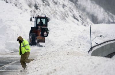 
Workers remove snow from  U.S. 40 in Arapaho National Forest in Colorado on Saturday after a huge avalanche swept two cars off the road. Eight people were rescued from the buried vehicles and all were taken to area hospitals, according to state Patrolman Eric Wynn. 
 (Associated Press / The Spokesman-Review)