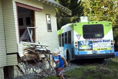 
Six-year-old Bradley Ross, who lives in the neighborhood, runs past the house at 17th and Perry that a bus hit Friday afternoon. 
 (Holly Pickett / The Spokesman-Review)