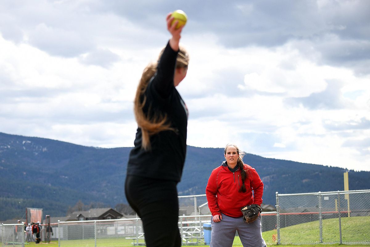Kaela DeBroeck, background, Post Falls High’s varsity pitching coach, works with senior Amanda Rouse at the school on Tuesday. (Kathy Plonka / The Spokesman-Review)