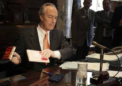 
Idaho Gov. Dirk Kempthorne pulls a large VETO stamp out of his desk Thursday. Kempthorne vetoed eight legislative bills Thursday to punish lawmakers who failed to pass his centerpiece highway legislation Wednesday night. 
 (Associated Press / The Spokesman-Review)
