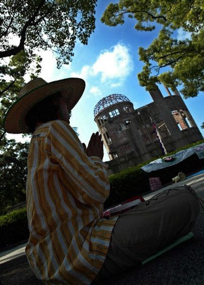 
A woman sits on the ground, offering prayers at the Atomic Bomb Dome in Hiroshima, Japan, on Thursday. The city marks the 60th anniversary of the atomic attack on Saturday. 
 (Associated Press / The Spokesman-Review)