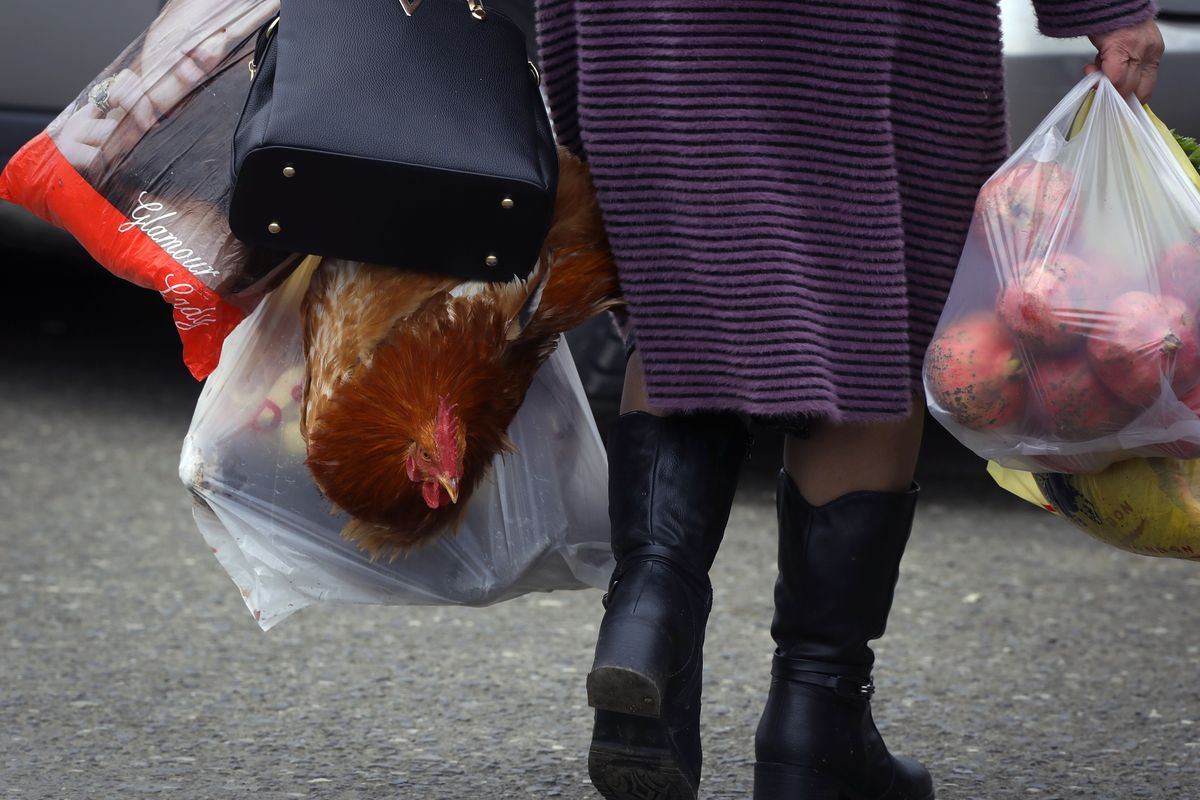 A woman carries her purchases and chicken at the market in Stepanakert, the capital of the separatist region of Nagorno-Karabakh, on Saturday, Nov. 21, 2020. Ethnic Armenians return to a normal life after a Russia-brokered cease-fire was signed between Armenia and Azerbaijan. (Sergei Grits)