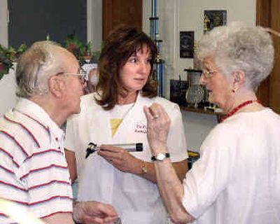 
Audiologist Tia Flynn, center, checks the hearing aid of Eric Youngson, with the assistance of Eric's wife, Helen.
 (Mike Kincaid/Handle Extra / The Spokesman-Review)