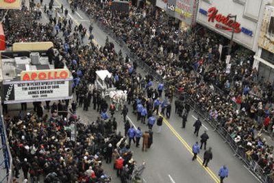 
The horse drawn carriage carrying James Brown's casket arrives at the Apollo Theater on Thursday in New York. A raucous throng of thousands cheered. 
 (Associated Press / The Spokesman-Review)
