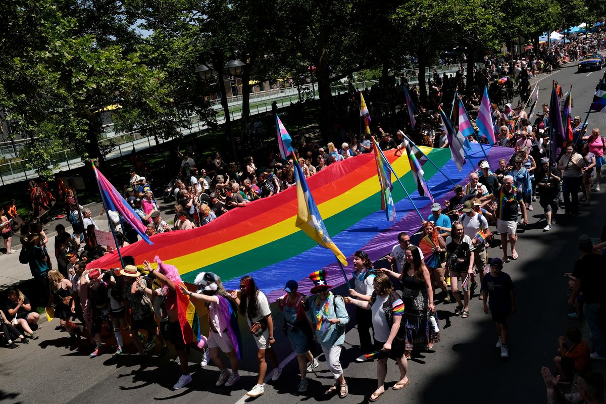 Participants carry a giant rainbow Pride flag Saturday in the Spokane Pride Parade downtown.  (Tyler Tjomsland/The Spokesman-Review)