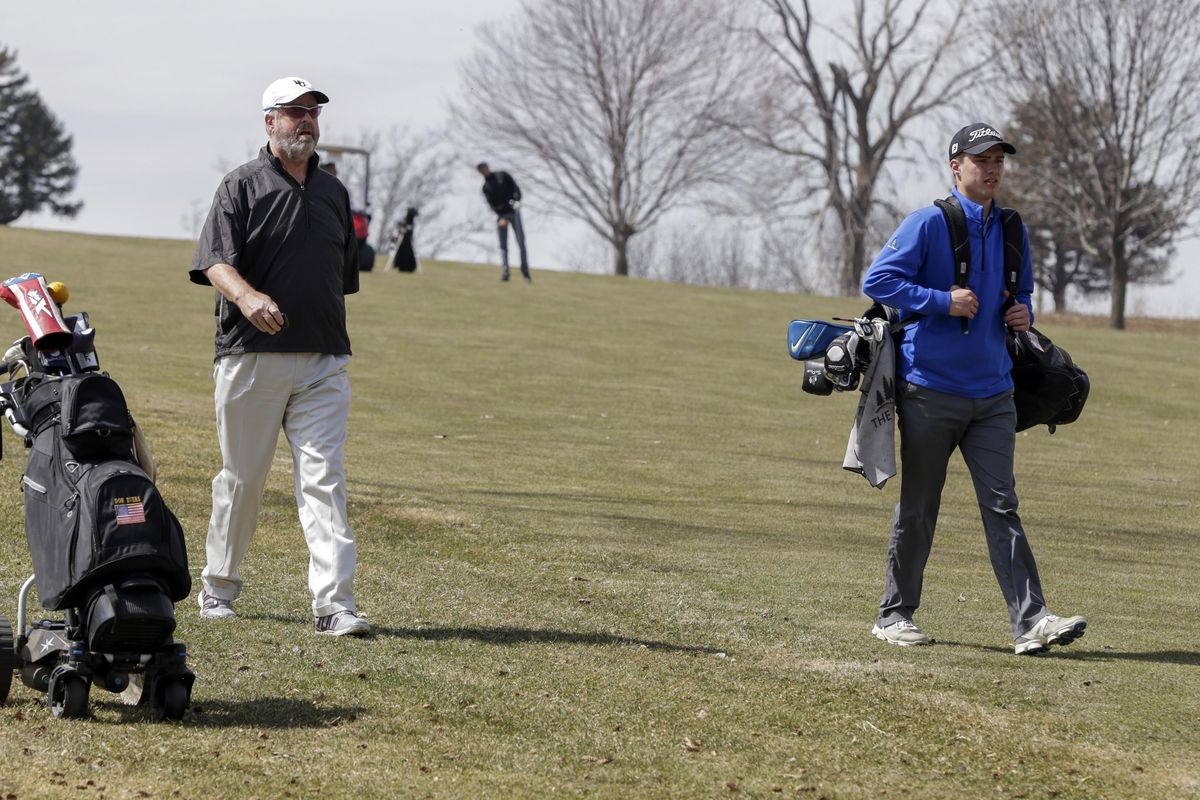 In this April 5, 2018 photo, Bellevue University golf team member Don Byers, left, walks alongside teammate Lucas Leinen during practice at the Platteview Golf Club in Bellevue, Neb. The 61-year-old Byers, who has had two knee surgeries and one on his back, said he would be physically unable to be on the team if he weren’t given a concession and allowed to put his clubs on a remote-control cart. (Nati Harnik / Associated Press)