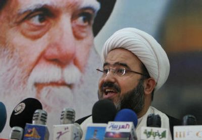 
Shiite cleric Abdul Hadi al-Daraji stands in front of a poster of the late Grand Ayatollah Mohammed Sadiq Al-Sadr before Friday prayers in Baghdad, Iraq.
 (Associated Press / The Spokesman-Review)