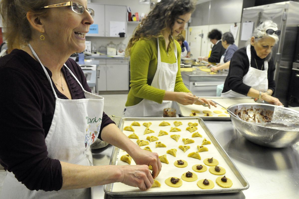 Annette Goldstein, left, chats while she works on triangular cookies, called hamantaschen, alongside Erin Kaya, center, and Frieda Levitch in the kitchen at Temple Beth Shalom. The cookies, a tradition during Purim, will be available during Sunday’s Kosher Dinner, a major fundraiser for the Temple. (Jesse Tinsley)