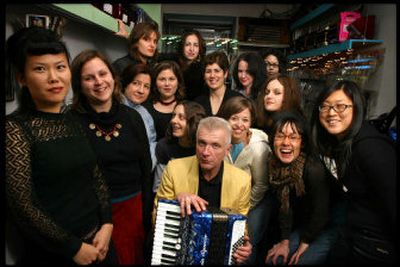 
Main Squeeze Orchestra members huddle around their conductor, Walter Kuehr, at his shop called Main Squeeze on Manhattan's Lower East Side. 
 (Associated Press / The Spokesman-Review)
