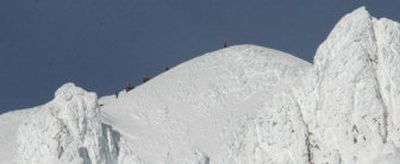 
Search and rescue personnel rest on the summit of Mount Hood on Monday after retrieving the body of climber Kelly James as they wait for helicopters to arrive. James' body was found in a snow cave Sunday, and the search for his two fellow climbers continues.
 (Associated Press / The Spokesman-Review)
