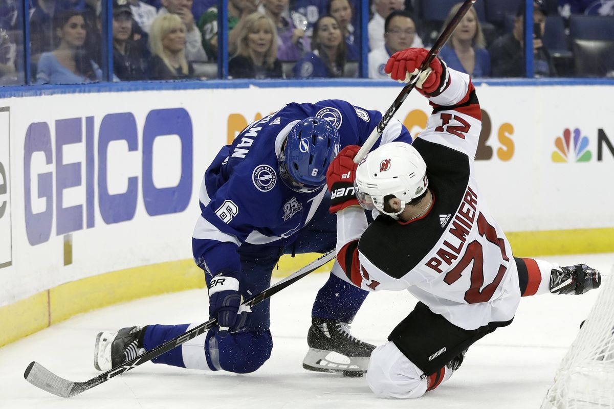 Tampa Bay Lightning defenseman Anton Stralman (6) and New Jersey Devils right wing Kyle Palmieri (21) collide whiles chasing the puck during the third period of Game 1 of an NHL first-round hockey playoff series Thursday, April 12, 2018, in Tampa, Fla. The Lightning won 5-2. (Chris O’Meara / Associated Press)