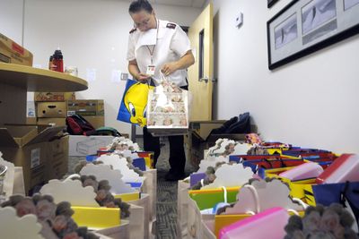 Capt. Katheleen Johnson of the Salvation Army packs school supply bags Thursday as other staffers work the phones to try to find more glue, erasers and binders.  (CHRISTOPHER ANDERSON / The Spokesman-Review)