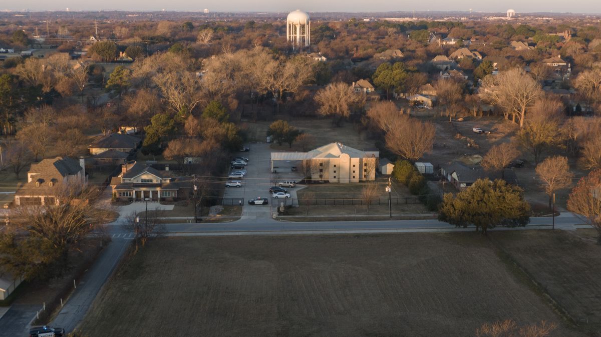 An aerial view of police standing in front of the Congregation Beth Israel synagogue, Sunday, Jan. 16, 2022, in Colleyville, Texas. A man held hostages for more than 10 hours Saturday inside the temple. The hostages were able to escape and the hostage taker was killed. FBI Special Agent in Charge Matt DeSarno said a team would investigate "the shooting incident."  (Brandon Wade)