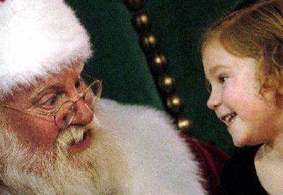 Rylie Thomas, 4, sits and giggles about how good she was this year as she visits with Santa Claus at River Park Sqare on Monday.
(The Spokesman-Review)
