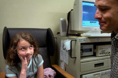 
Katelyn Schmidt, 9, considers a surgery to remove her ear tubes while consulting Friday with Dr. Michael Olds, an ear, nose and throat physician and member of the cleft palate team. Schmidt was born with a cleft palate and cleft lip, and has undergone five surgeries. 
 (Holly Pickett / The Spokesman-Review)