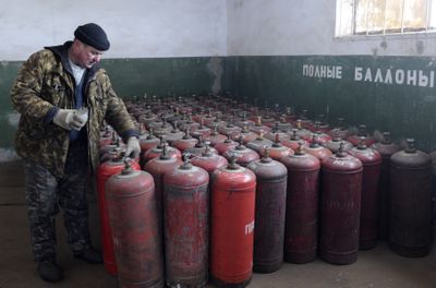 A Ukrainian worker prepares Tuesday to load gas containers at a gas station in Brovary, Ukraine, that works with small consumers such as householders. Brovary is 12.5 miles northwest of Kiev.  (Associated Press / The Spokesman-Review)