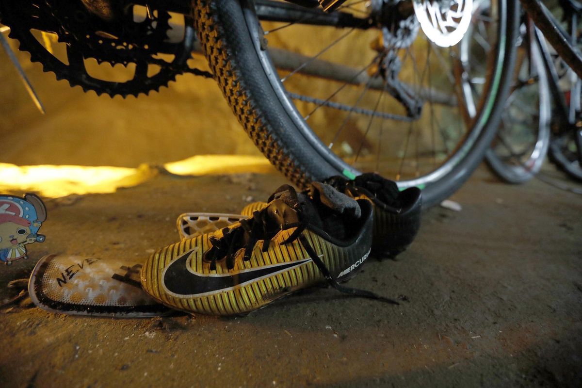 A pair of soccer shoes are left next to bicycles from a group of missing boys at the entrance of a deep cave in Chiang Rai, northern Thailand, Monday, June 25, 2018. (Thai News Pix / Associated Press)