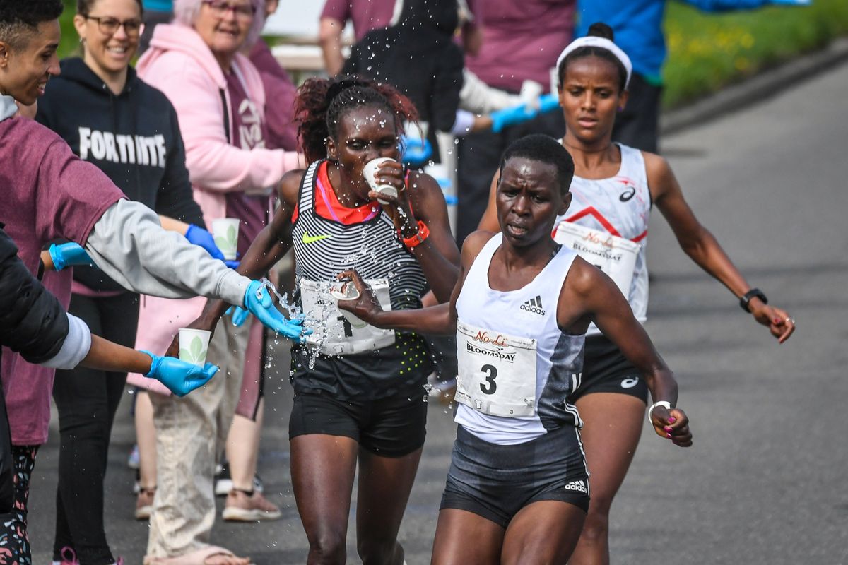 Elite women runners, Daisy Kimeli (3), Cynthia Limo (1) and race winner Yeshi Kalay Chekole crash the water station atop Doomsdayhill during Bloomsday 2023.  (DAN PELLE/THE SPOKESMAN-REVIEW)