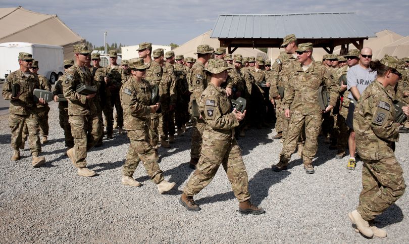 About 120 members of the Iowa National Guard, part of an advance crew for the 2nd Brigade Combat Team, waited patiently in lines Sunday outside of a Manas supply tent, where they filed in based on body size to be issued body armor. (Colin Mulvany / The Spokesman-Review)