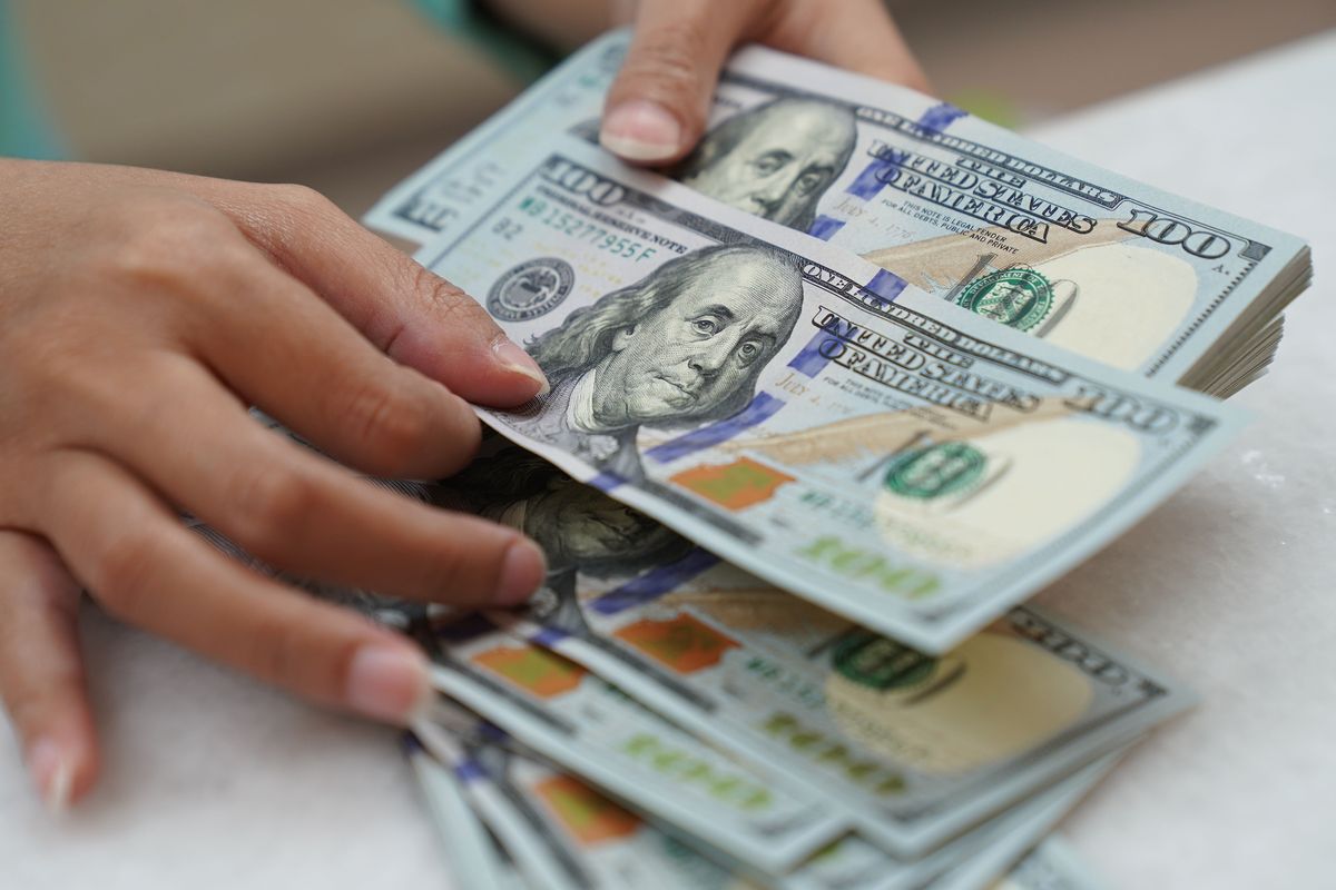 A clerk counts U.S. dollar banknotes at a currency exchange office in Jakarta, Indonesia, on March 2, 2022. A bank manager in Pullman used a ruse to slowly count cash when a Garfield man believed his daughter had been kidnapped. (Dimas Ardian/Bloomberg)