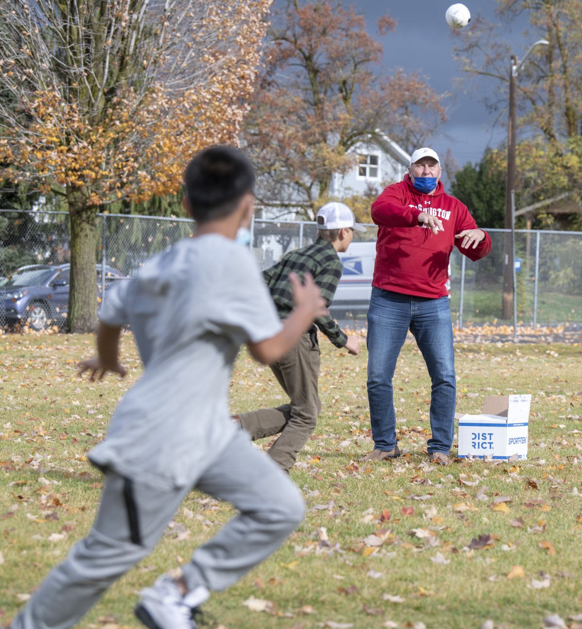 Former NFL quarterback Mark Rypien, upper right, throws a ball intended for sixth-grader Jenton Clement, left, on the playfield at Willard Elementary School on Friday, Oct. 29, 2021, in Spokane, Wash. Teaching assistant Chauncy Welliver invited Rypien, the 1992 Super Bowl MVP, to talk to the students and for each of them to have a chance to catch a pass from Rypien on the playground.  (Jesse Tinsley/THE SPOKESMAN-REVI)