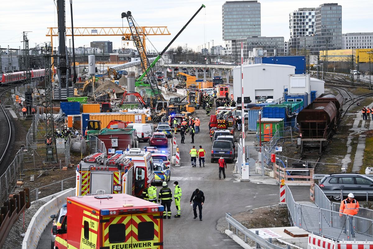 Firefighters, police officers and railway employees stand on a railway site Wednesday in Munich, Germany.  (Sven Hoppe)