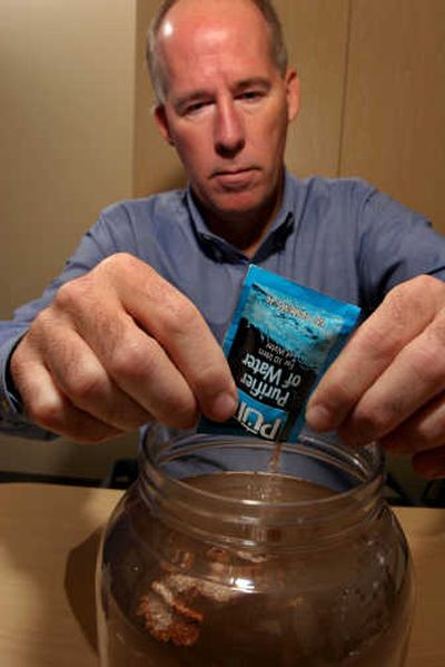 
Greg Allgood, director of the Children's Safe Drinking Water project for Proctor & Gamble, adds PUR water purifier to a jar of dirty water at the P&G headquarters in Cincinnati, Ohio. Associated Press
 (File Associated Press / The Spokesman-Review)